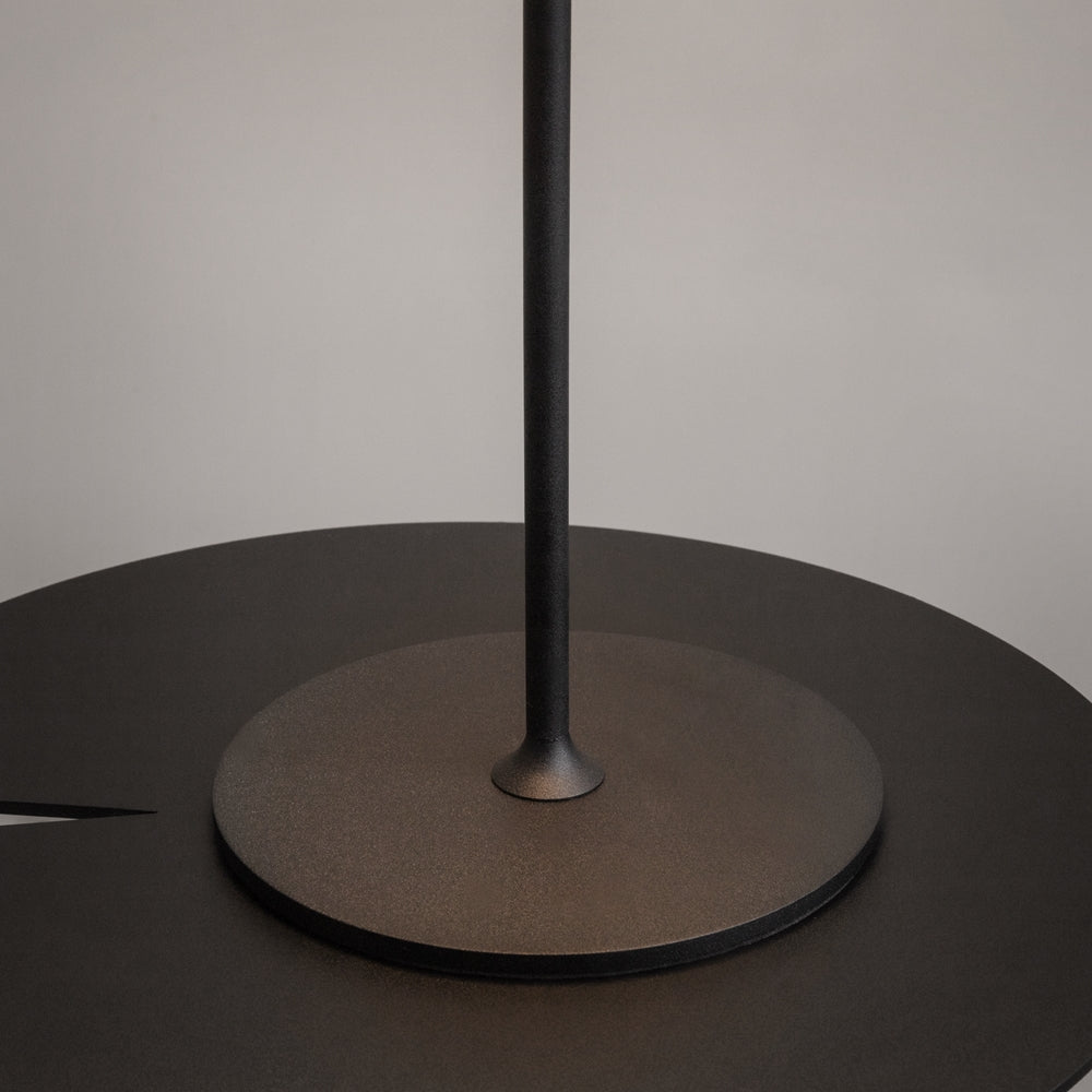 Détail du pied circulaire noir et de la base effilée de la tige